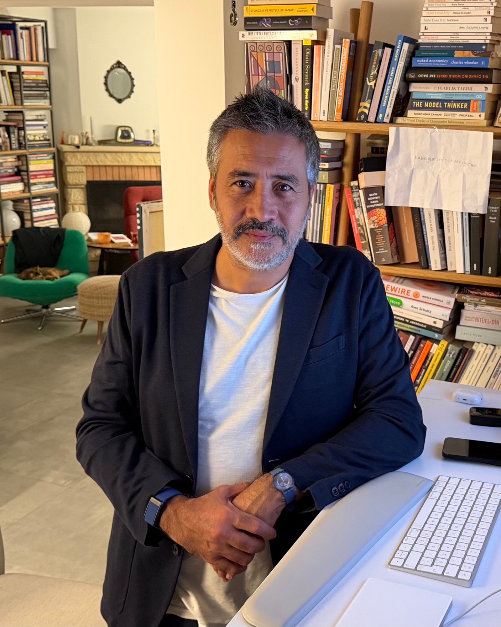 Emre Güneş in front of his book wall