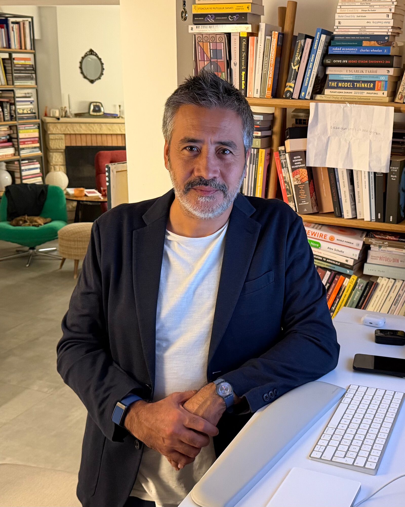 Emre Güneş in front of his book wall